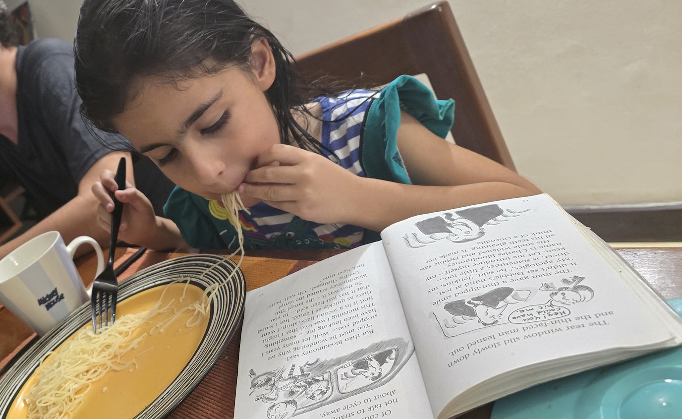 Toma was caught reading having a meal.jpg